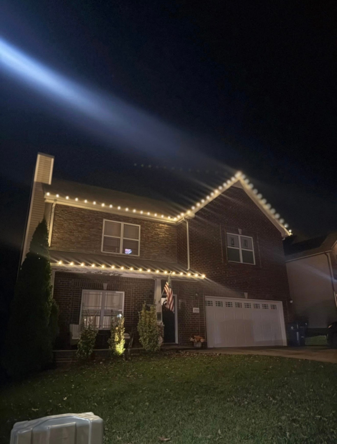 Brick home with warm white roofline Christmas lights